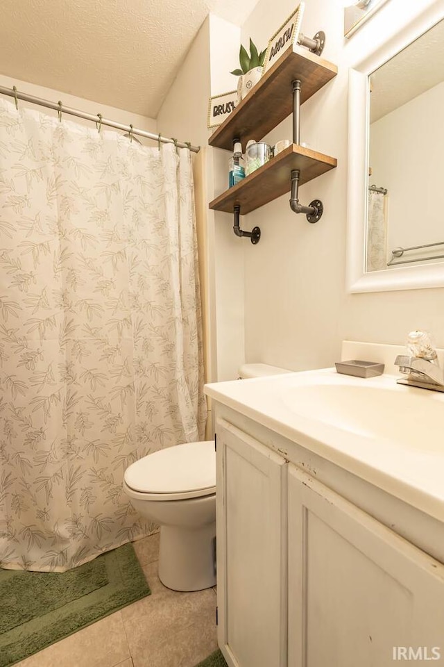 3879 Woodmere Way, Bloomington, IN 47403 - full bathroom featuring vanity, toilet, tile patterned flooring, a textured ceiling, and a shower with curtain