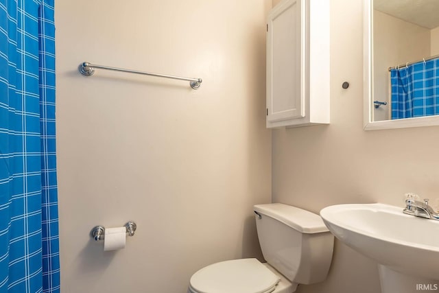 3879 Woodmere Way, Bloomington, IN 47403 - bathroom featuring toilet, a sink, and a shower with curtain