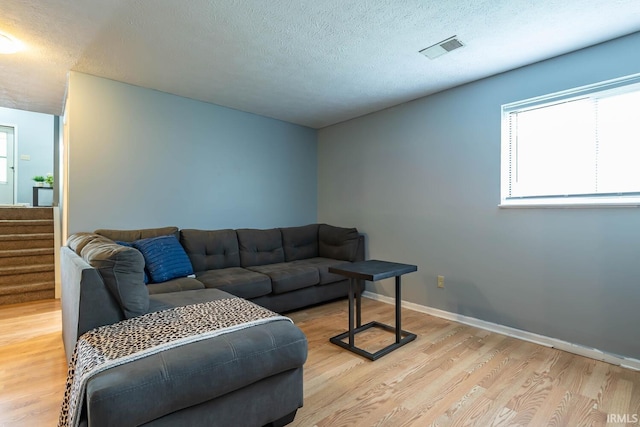 3879 Woodmere Way, Bloomington, IN 47403 - living room featuring light wood-type flooring, stairway, a textured ceiling, and baseboards