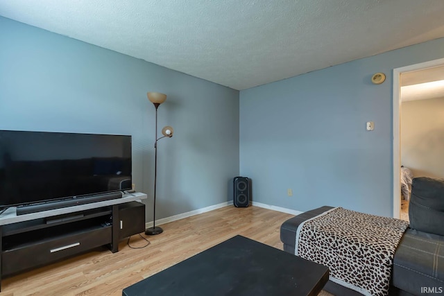 3879 Woodmere Way, Bloomington, IN 47403 - living area with wood finished floors, baseboards, and a textured ceiling