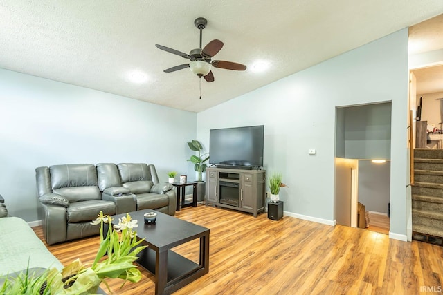 3879 Woodmere Way, Bloomington, IN 47403 - living room with vaulted ceiling, ceiling fan, stairway, light wood-style floors, and baseboards