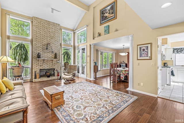 3455 Bridgetown Rd, Bristol, IN 46507 - living room with wood finished floors, baseboards, high vaulted ceiling, a fireplace, and beam ceiling
