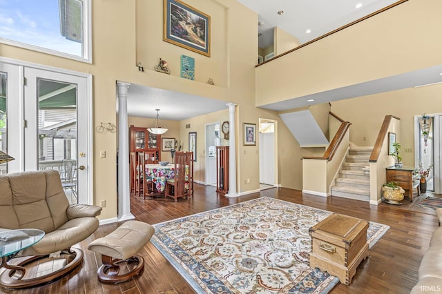 3455 Bridgetown Rd, Bristol, IN 46507 - living room with decorative columns, baseboards, wood finished floors, a towering ceiling, and stairs