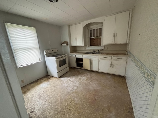 6714 Bradbury Ave, Fort Wayne, IN 46809 - kitchen with white range with electric stovetop, a sink, light countertops, and white cabinetry