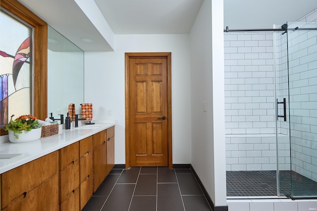 full bath with tile patterned flooring, a shower stall, double vanity, and baseboards