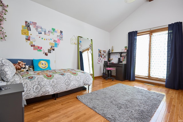 bedroom featuring light wood-type flooring and high vaulted ceiling