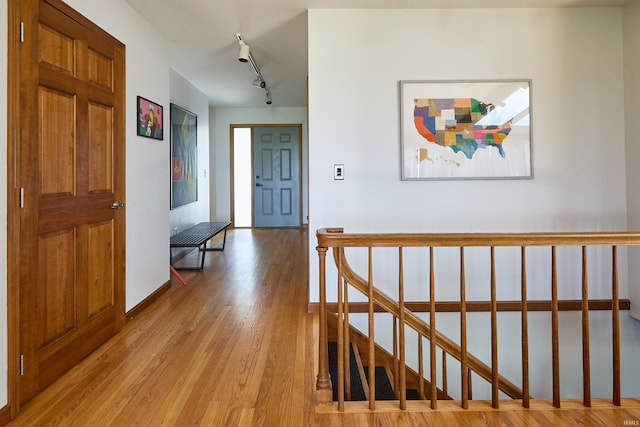 entryway featuring light wood-style flooring, baseboards, and track lighting