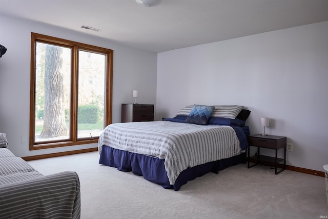 carpeted bedroom with multiple windows and baseboards
