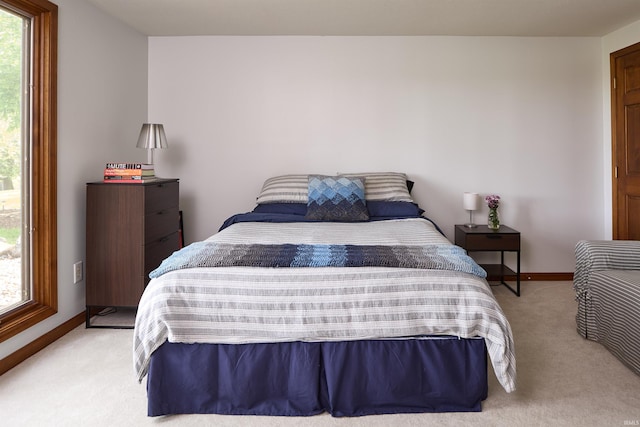 bedroom with carpet floors, multiple windows, and baseboards