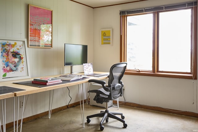 home office featuring concrete floors and baseboards