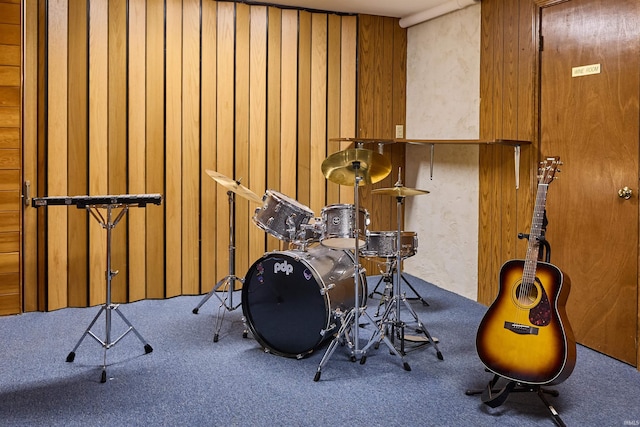 misc room featuring carpet flooring and wooden walls
