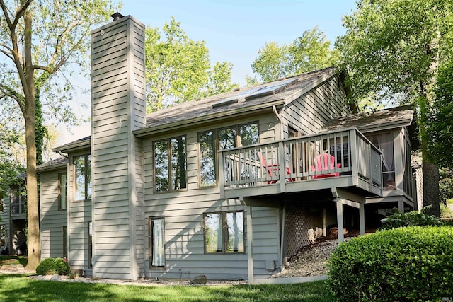 rear view of house featuring a chimney and a deck