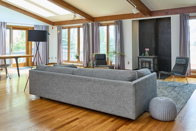 living room featuring healthy amount of natural light, wood finished floors, and a skylight