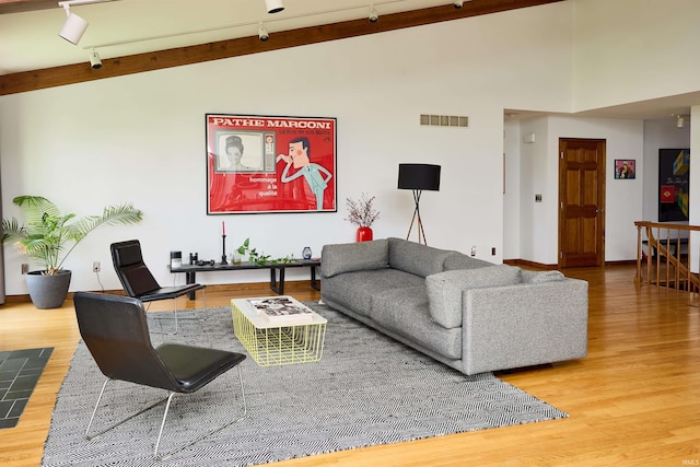 living room featuring wood finished floors, track lighting, and baseboards