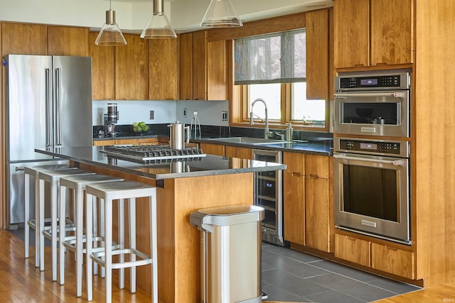kitchen featuring stainless steel appliances, beverage cooler, a sink, and brown cabinetry