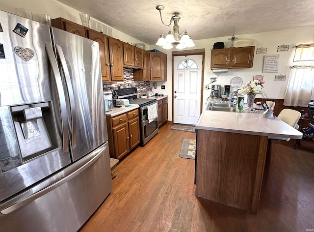 2855 N 525 W, Crawfordsville, IN 47933 - kitchen with appliances with stainless steel finishes, a sink, light wood-style floors, a textured ceiling, and a chandelier
