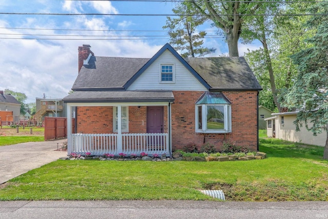 120 W Williams St, Chandler, IN 47610 - view of front facade with a porch, brick siding, a front lawn, and a chimney
