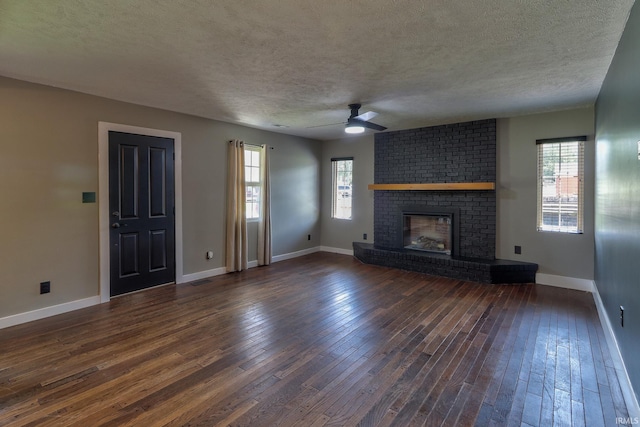 120 W Williams St, Chandler, IN 47610 - unfurnished living room with a textured ceiling, a ceiling fan, plenty of natural light, dark wood-style floors, and a fireplace