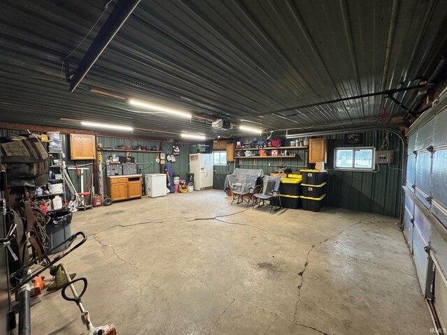6008 N 600 E, Rochester, IN 46975 - garage featuring white refrigerator with ice dispenser, a garage door opener, and a workshop area