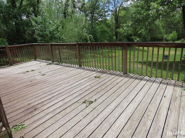 wooden terrace featuring a yard and view of wooded area