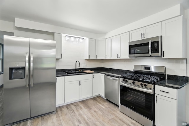 3560 Sandpoint Rd, Fort Wayne, IN 46809 - kitchen with stainless steel appliances, a sink, decorative backsplash, white cabinets, and light wood-style flooring
