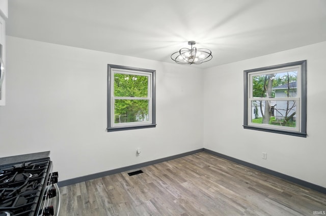 3560 Sandpoint Rd, Fort Wayne, IN 46809 - unfurnished dining area featuring plenty of natural light, a chandelier, wood finished floors, and baseboards