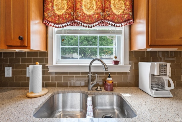 3934 Rushgrove Dr, Lafayette, IN 47909 - kitchen featuring a sink, decorative backsplash, and brown cabinetry