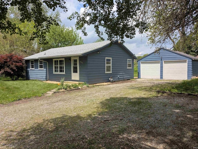 ranch-style home with a detached garage, an outbuilding, and a front yard