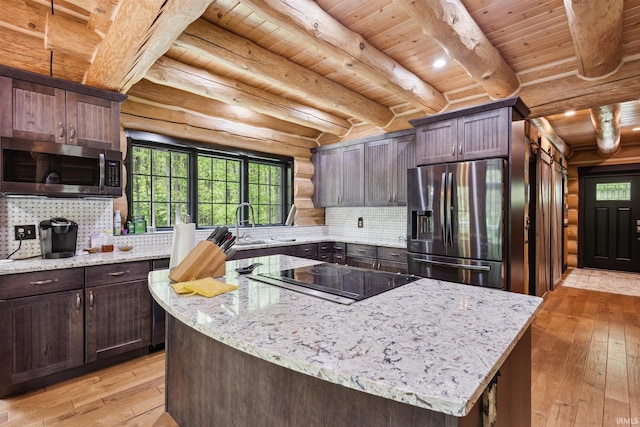 7428 E 400 N Rd, Rolling Prairie, IN 46371 - kitchen featuring stainless steel appliances, light wood finished floors, log walls, light stone counters, and wooden ceiling with exposed beams