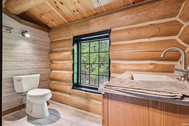 7428 E 400 N Rd, Rolling Prairie, IN 46371 - half bath featuring rustic walls, toilet, wooden ceiling, a sink, and wood finished floors