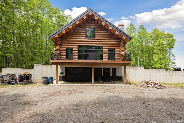 7428 E 400 N Rd, Rolling Prairie, IN 46371 - view of front of house with a chimney, log exterior, dirt driveway, and a deck
