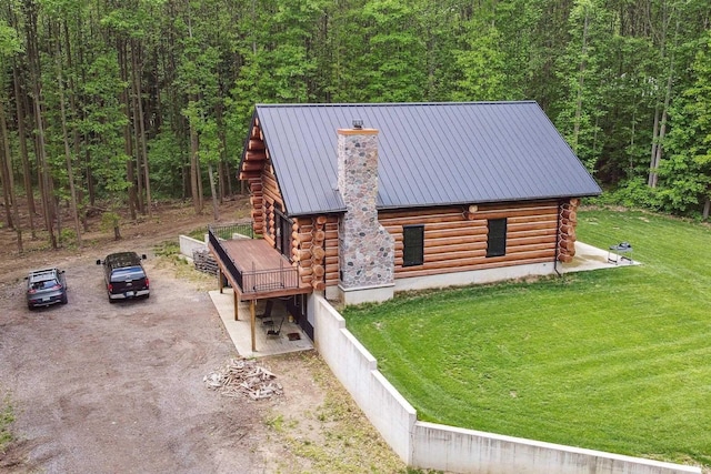 7428 E 400 N Rd, Rolling Prairie, IN 46371 - view of side of property featuring log exterior, a chimney, a wooded view, a standing seam roof, and metal roof