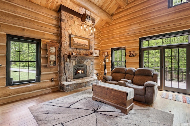7428 E 400 N Rd, Rolling Prairie, IN 46371 - living area featuring log walls, a stone fireplace, wood-type flooring, wood ceiling, and healthy amount of natural light