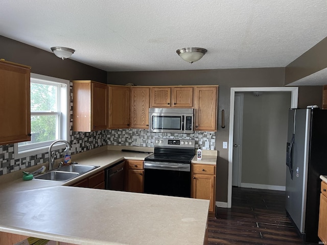 201 Riley Dr, Fort Wayne, IN 46825 - kitchen with stainless steel appliances, a sink, light countertops, dark wood finished floors, and a textured ceiling