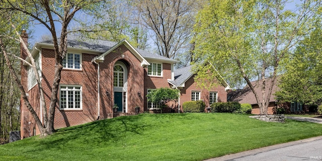 9838 Gulfstream Ct, Fishers, IN 46037 - traditional-style home with a chimney, brick siding, a front lawn, and roof with shingles