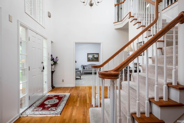 9838 Gulfstream Ct, Fishers, IN 46037 - entrance foyer featuring stairway, wood finished floors, a towering ceiling, baseboards, and a chandelier