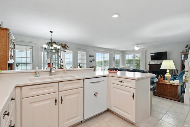 kitchen with dishwasher, open floor plan, a sink, light tile patterned flooring, and a ceiling fan