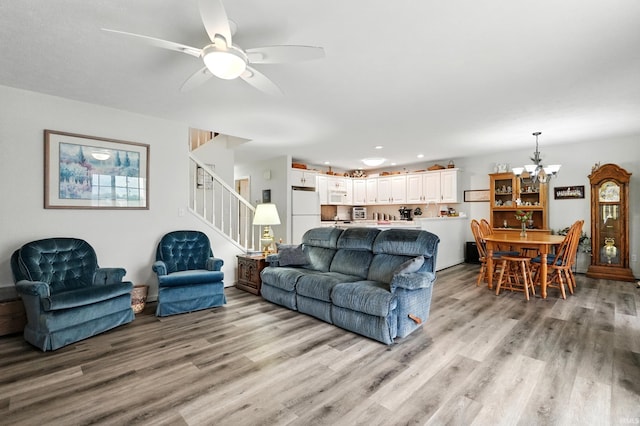 living area with a chandelier, stairway, light wood finished floors, a ceiling fan, and recessed lighting