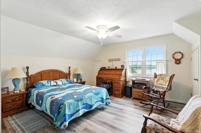 bedroom with light wood-type flooring, vaulted ceiling, ceiling fan, and a closet