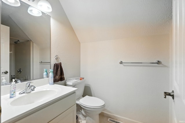full bath with vaulted ceiling, vanity, a shower, toilet, and baseboards