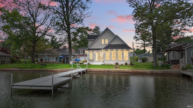 dock area with a water view and a lawn