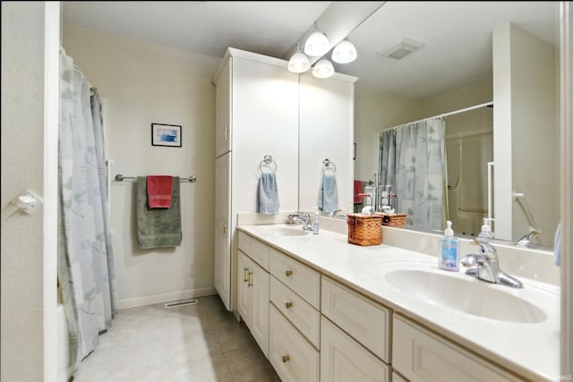 bathroom with tile patterned floors, double vanity, a shower with shower curtain, and baseboards