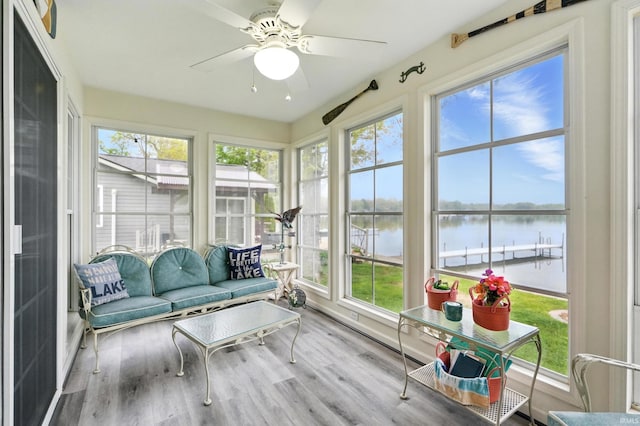 sunroom / solarium with a water view, plenty of natural light, and wood finished floors
