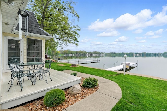 dock with a lawn, a water view, and boat lift