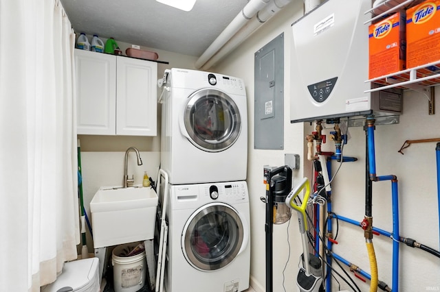 laundry area with stacked washer and clothes dryer, cabinet space, water heater, and electric panel
