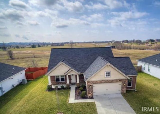 3102 Paradise Cir, Newburgh, IN 47630 - view of front facade featuring driveway, a garage, a front yard, and a view of rural / pastoral area