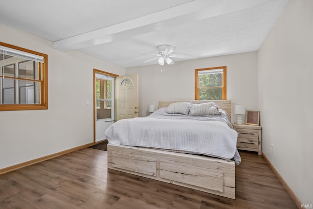 bedroom featuring baseboards, wood finished floors, beamed ceiling, ceiling fan, and access to exterior
