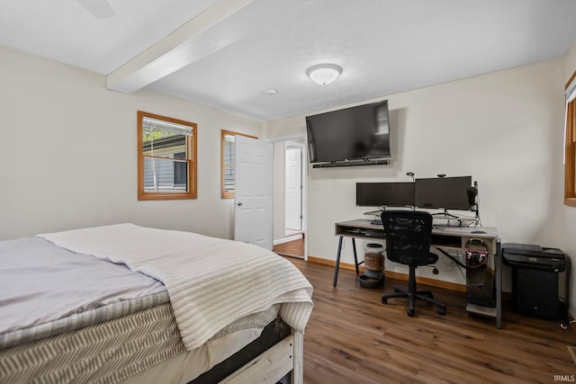 bedroom featuring wood finished floors, a desk, beam ceiling, and baseboards