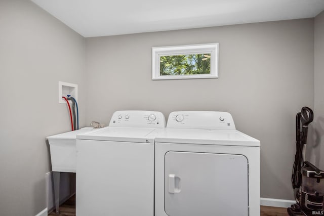 washroom with washing machine and dryer, baseboards, and dark wood-style flooring