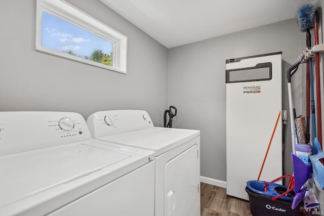 laundry room with washing machine and dryer, wood finished floors, and baseboards